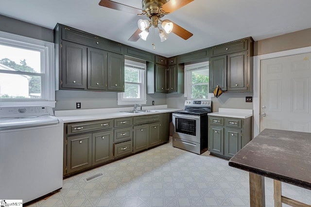 kitchen featuring ceiling fan, a healthy amount of sunlight, stainless steel range with electric cooktop, and washer / clothes dryer