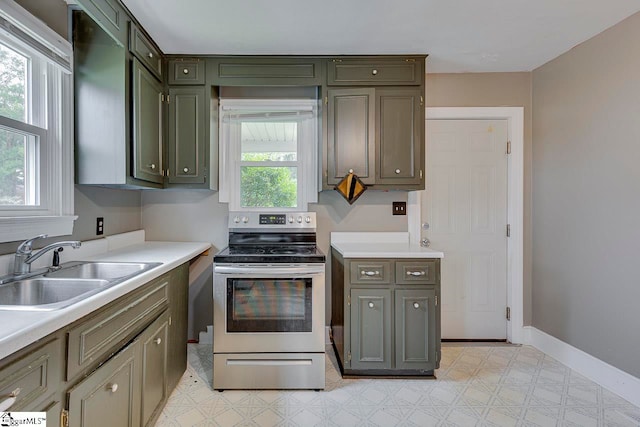 kitchen featuring a wealth of natural light, green cabinets, stainless steel range with electric stovetop, and sink