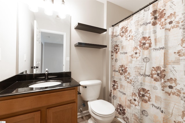 bathroom featuring curtained shower, vanity, and toilet