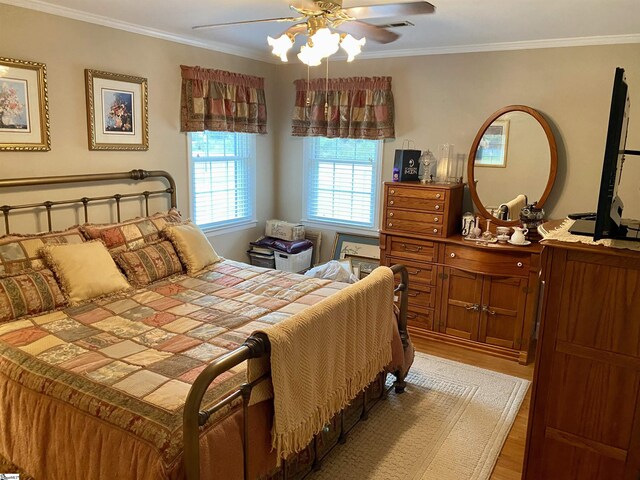 bedroom with ceiling fan, hardwood / wood-style floors, and ornamental molding