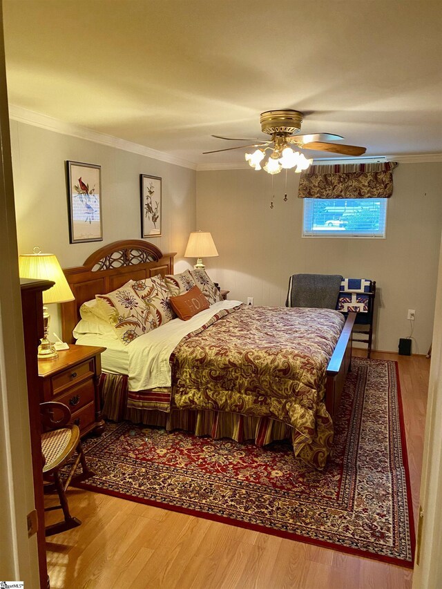 bedroom featuring ceiling fan, crown molding, and hardwood / wood-style floors