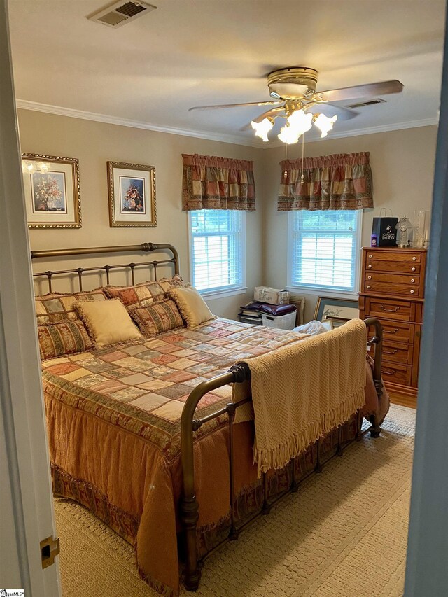 carpeted bedroom featuring ceiling fan, crown molding, and multiple windows