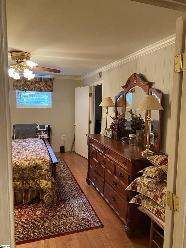 bedroom featuring ornamental molding, light hardwood / wood-style floors, and ceiling fan