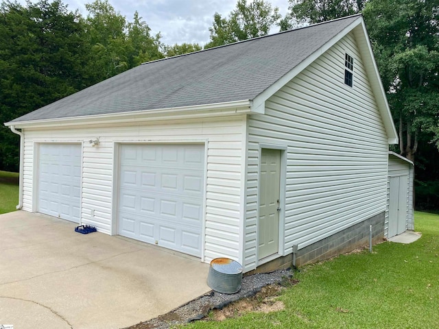 garage with a lawn and wood walls