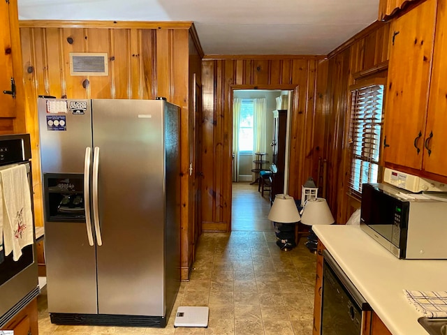 kitchen featuring stainless steel appliances, wood walls, and ornamental molding