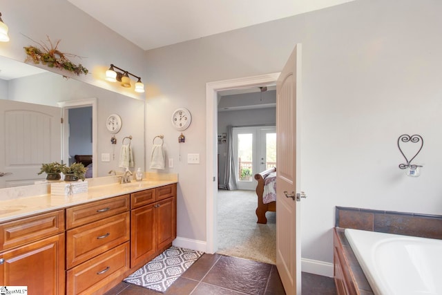 bathroom featuring tile patterned floors, a tub to relax in, and vanity