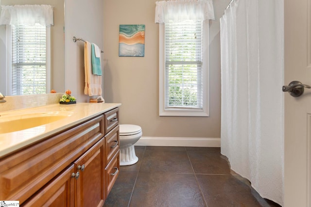 bathroom with tile patterned flooring, vanity, toilet, and plenty of natural light