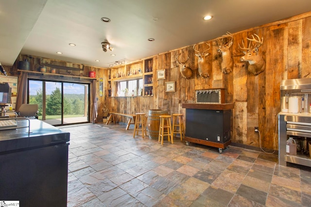 interior space with fridge and wood walls