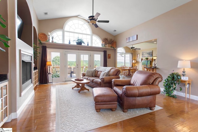 living room featuring ceiling fan, light hardwood / wood-style flooring, french doors, and high vaulted ceiling