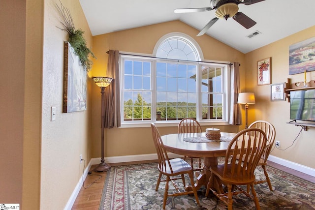 dining area with wood-type flooring, vaulted ceiling, ceiling fan, and plenty of natural light