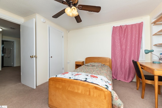 bedroom featuring light carpet, ceiling fan, and a textured ceiling