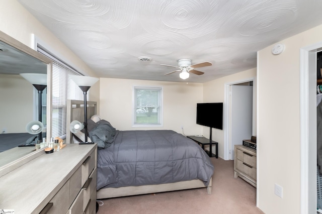 bedroom featuring ceiling fan and light carpet