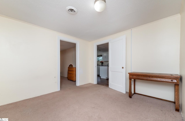 carpeted empty room featuring a textured ceiling