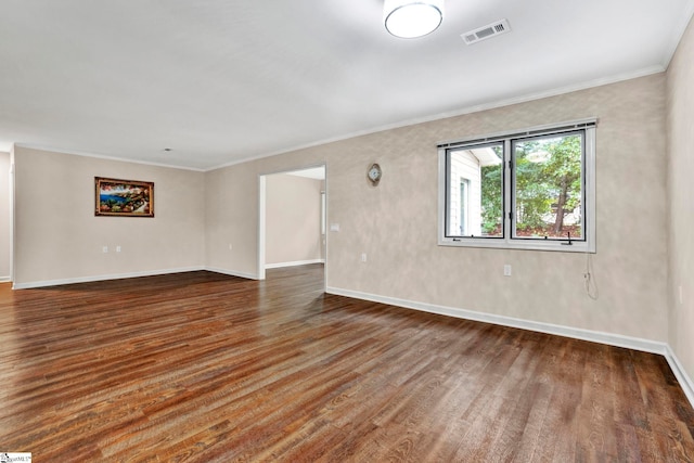 empty room featuring dark hardwood / wood-style floors and crown molding