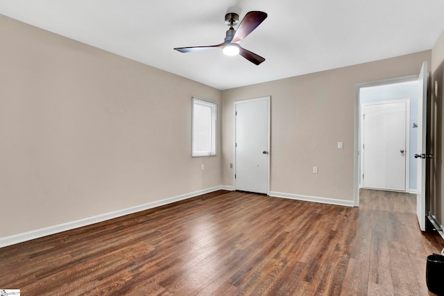 empty room with dark hardwood / wood-style floors and ceiling fan