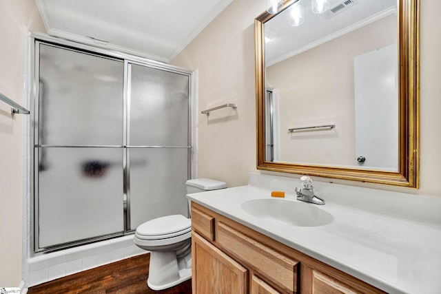 bathroom with vanity, ornamental molding, hardwood / wood-style flooring, walk in shower, and toilet