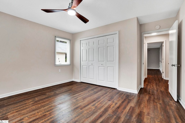 unfurnished bedroom featuring dark hardwood / wood-style flooring, ceiling fan, and a closet