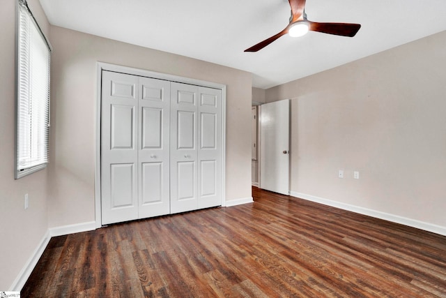 unfurnished bedroom with a closet, ceiling fan, and dark wood-type flooring