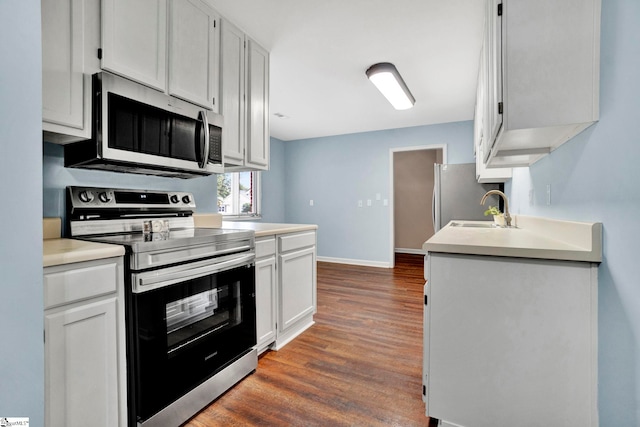 kitchen featuring white cabinets, appliances with stainless steel finishes, dark wood-type flooring, and sink