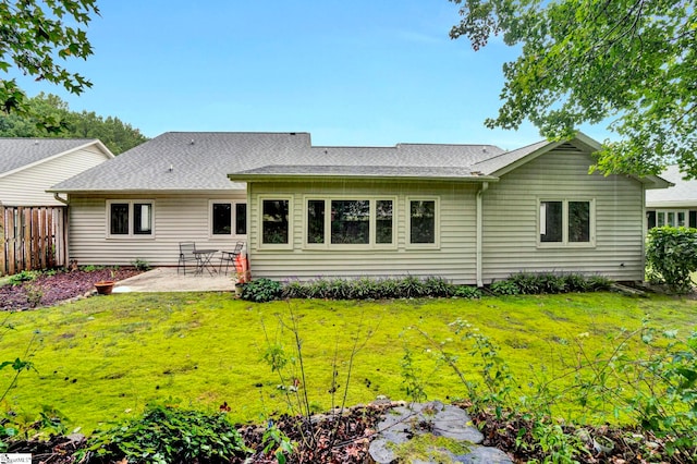 rear view of property featuring a patio area and a yard