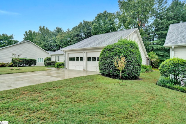 view of side of property with a garage and a lawn