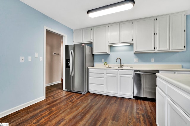 kitchen featuring white cabinetry, appliances with stainless steel finishes, dark wood-type flooring, and sink