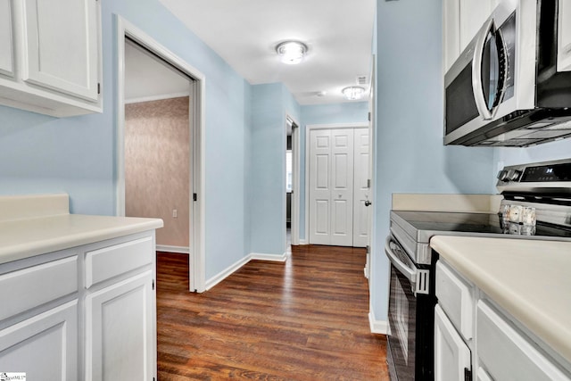 kitchen featuring appliances with stainless steel finishes, white cabinetry, and dark hardwood / wood-style floors