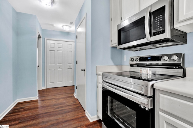 kitchen featuring stainless steel appliances, white cabinetry, and dark hardwood / wood-style floors