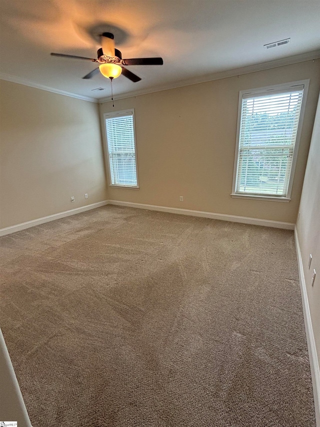 carpeted empty room featuring ceiling fan and crown molding