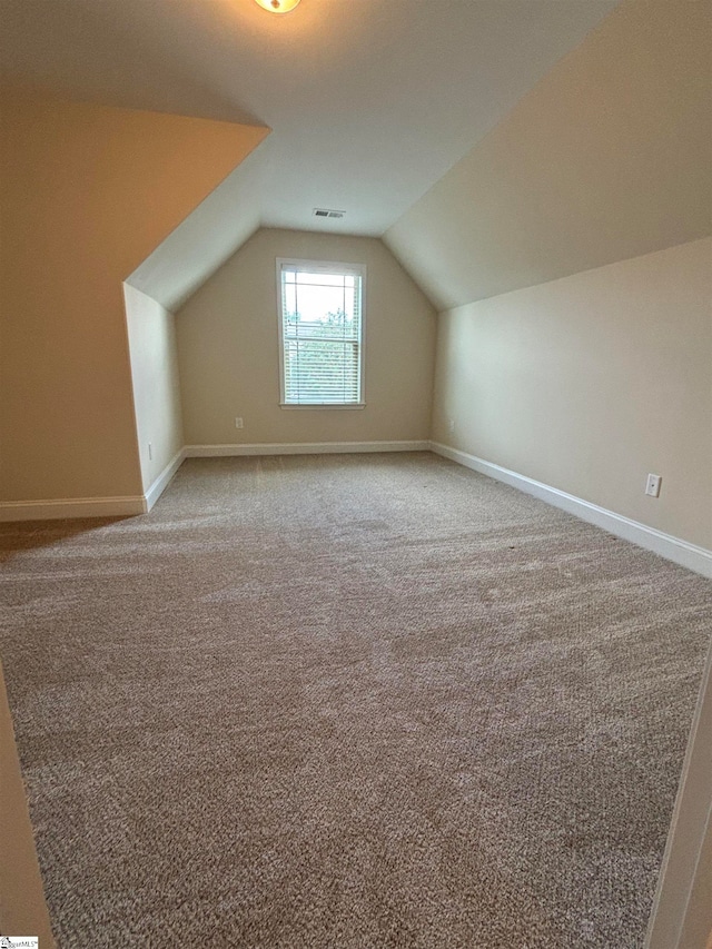 bonus room featuring lofted ceiling and carpet flooring