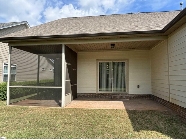 property entrance featuring a lawn and a patio area