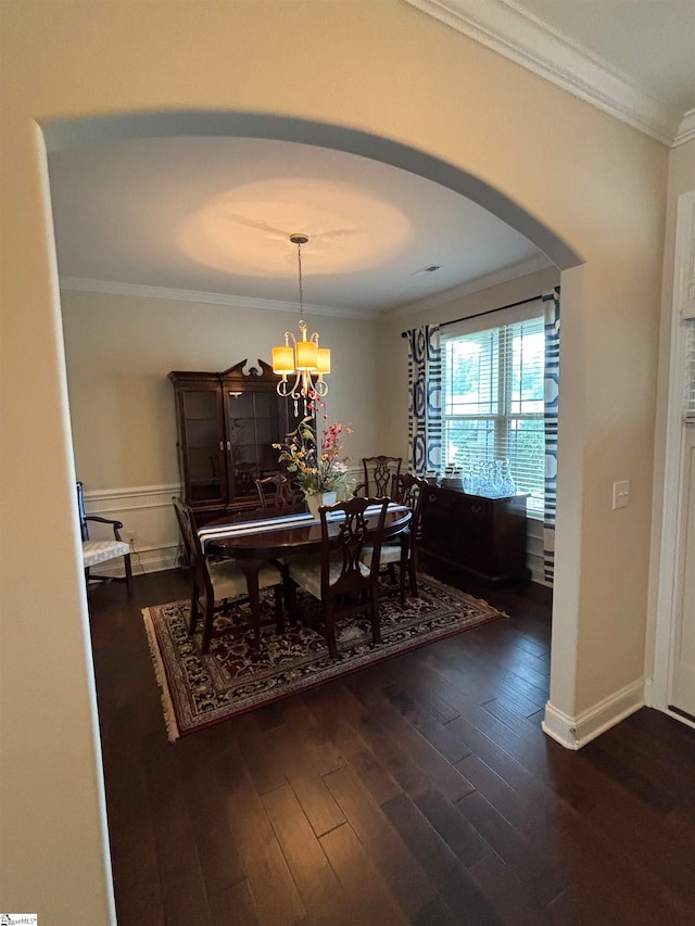 dining room with an inviting chandelier, ornamental molding, and dark hardwood / wood-style flooring