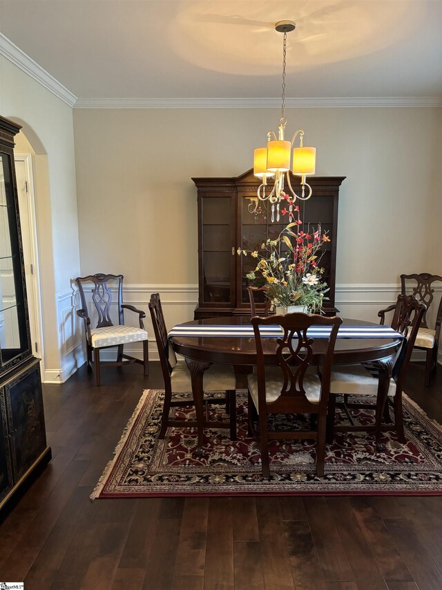 dining area with ornamental molding, dark hardwood / wood-style flooring, and a notable chandelier