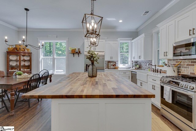 kitchen featuring wooden counters, visible vents, an inviting chandelier, and appliances with stainless steel finishes