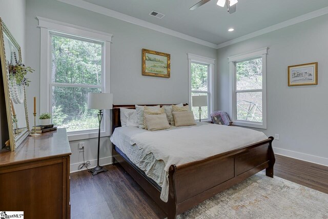 bedroom featuring ornamental molding, visible vents, multiple windows, and dark wood finished floors