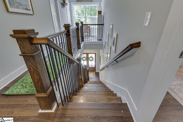 stairway featuring baseboards and wood finished floors
