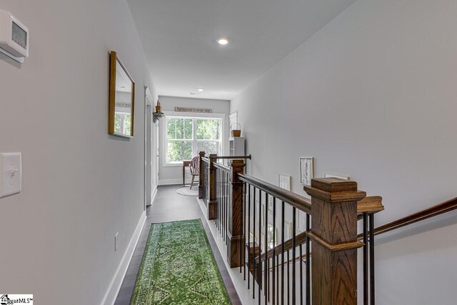 corridor with an upstairs landing, baseboards, and recessed lighting