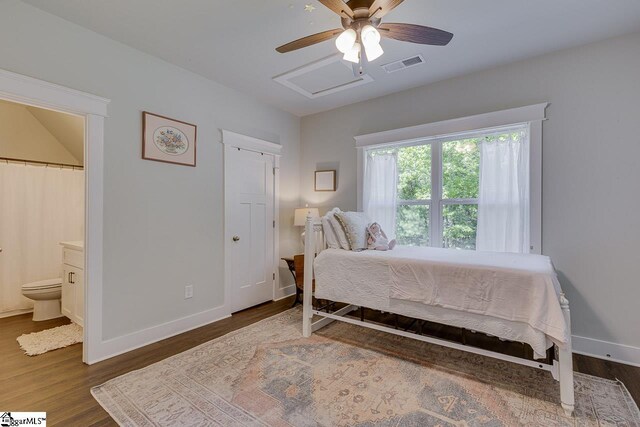 bedroom with wood finished floors, ensuite bathroom, baseboards, and visible vents