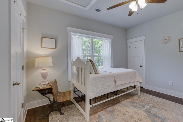 bedroom featuring wood finished floors, baseboards, and visible vents