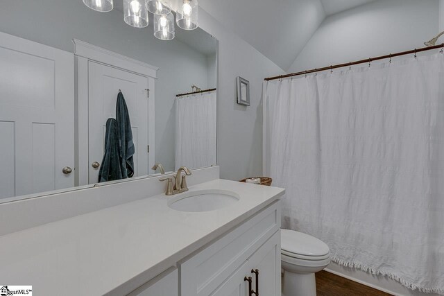 full bathroom with vanity, lofted ceiling, an inviting chandelier, toilet, and wood finished floors