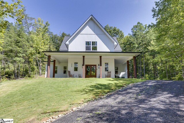 view of front facade with a front lawn, gravel driveway, and french doors