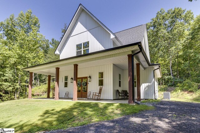 view of front of house with a shingled roof, a front lawn, and french doors