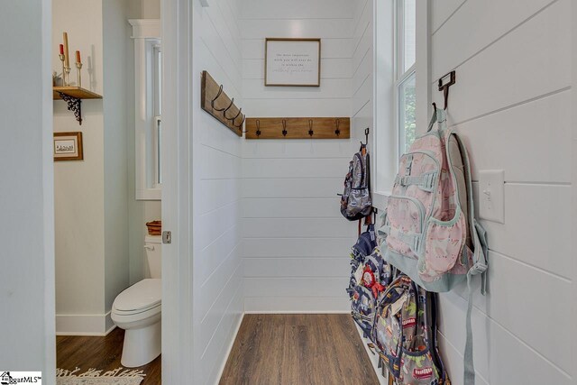 bathroom with baseboards, wood finished floors, and toilet