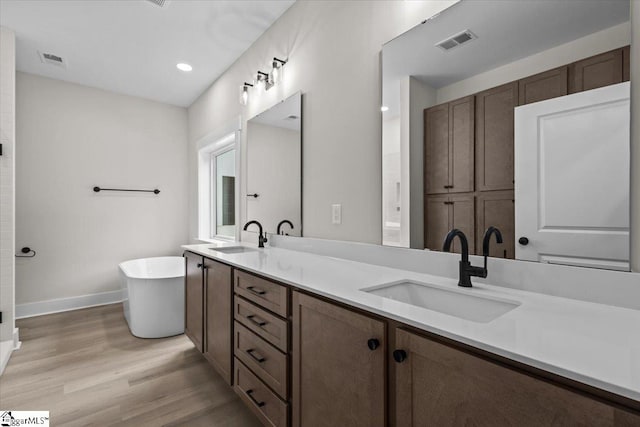 bathroom with vanity, hardwood / wood-style flooring, and a bathing tub