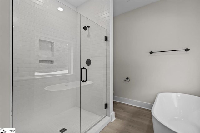 bathroom with hardwood / wood-style flooring and plus walk in shower