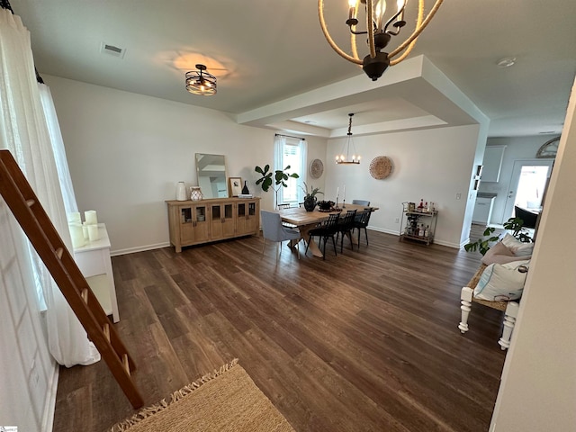 dining room featuring a notable chandelier, a tray ceiling, and dark hardwood / wood-style floors