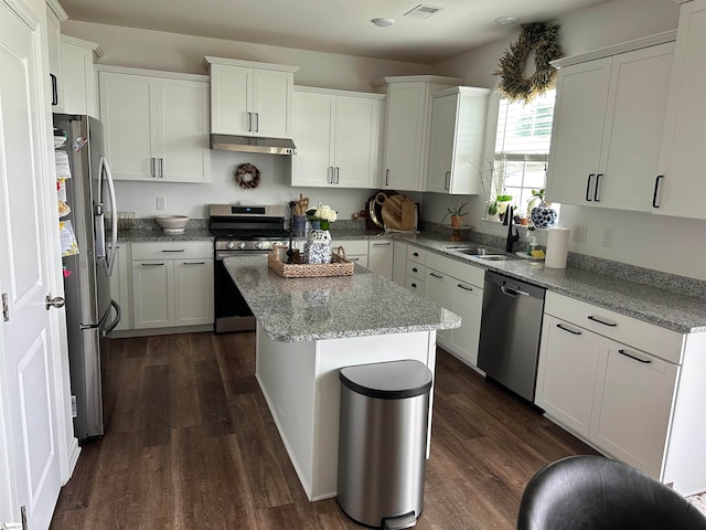 kitchen featuring sink, white cabinetry, stainless steel appliances, a center island, and dark hardwood / wood-style flooring