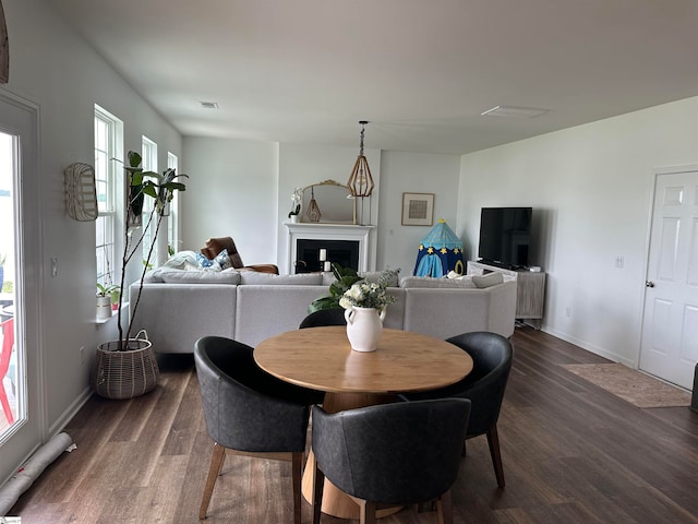 dining room with a healthy amount of sunlight and dark hardwood / wood-style flooring