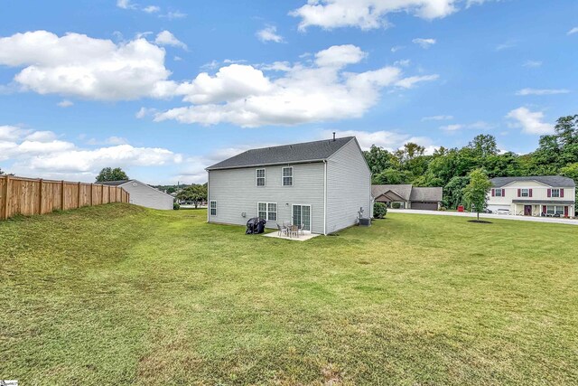 rear view of property featuring a lawn and a patio