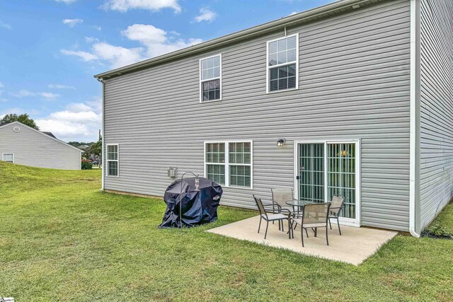 back of property featuring a lawn and a patio area